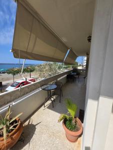 a balcony with potted plants and a view of the ocean at Kons beach front in Kalamata