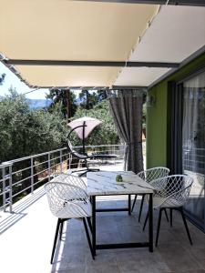 a patio with a table and chairs on a balcony at Black Goat in Chrysi Ammoudia
