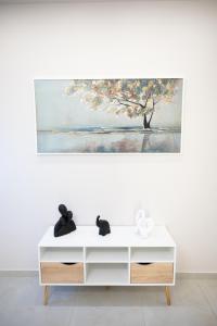 eine weiße Kommode mit einem Gemälde an der Wand in der Unterkunft Chariklia Studios in Asmínion + 119 Fotos