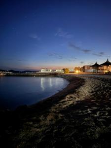een nachtelijk uitzicht op een strand met huizen en het water bij Mobile Enelia sun house in Sveti Petar