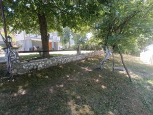 un mur de pierre à côté d'un arbre et d'un bâtiment dans l'établissement Tranquil Retreat - "Villa Green Oasis", à Sarajevo