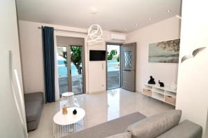 ein Wohnzimmer mit Sofa und Tisch in der Unterkunft Chariklia Studios in Asmínion