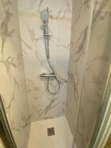 a shower with a shower head in a bathroom at Le studio de Manon in Carquefou +5 photos