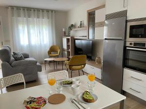 a kitchen and living room with a table with glasses of orange juice at Casa da tía María , Razo , Costa da Morte in Razo da Costa
