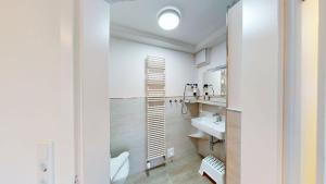 a white bathroom with a sink and a toilet at Haus Ostwind OSTWIND 'Groot Pläseer' in Langeoog +21 photos