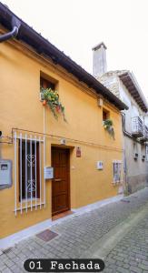 a yellow building with a door on a street at La casita de Elizabeth in San Martín de Unx