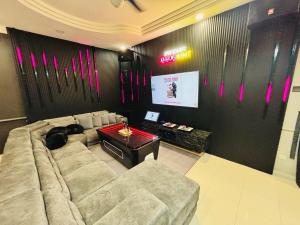 a living room with a couch and a screen at Kulai Neon Bliss Villa in Kulai