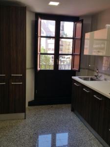 uma cozinha com uma porta preta e um lavatório em Apartamento Capitania em Granada