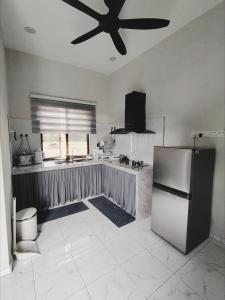 a kitchen with a refrigerator and a ceiling fan at Homestay De'daun kulim mus'lim only in Kulim