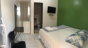 a bedroom with a bed and a green wall at Hotel do Hulk in Barreirinhas