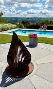 a large metal sculpture in front of a swimming pool at La Perle du Fierain in Wegnez +30 photos