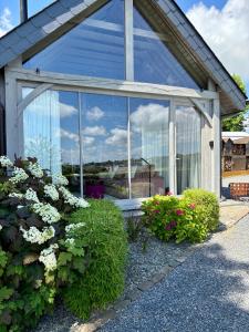 a glass house with flowers in front of it at La Perle du Fierain in Wegnez