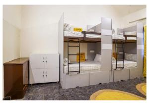 a room with three bunk beds and a desk at The Pune Story in Pune