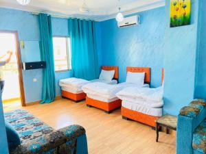 a blue room with two beds and two chairs at 2bedroom apartment with balcony in Aqaba
