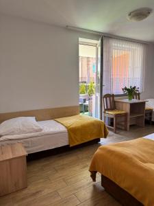 a bedroom with two beds and a table and a chair at Pokoje Gościnne u Małgosi in Mielno +90 photos