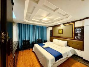 ハノイにあるChurch Legend Hotelのベッドルーム1室(青いカーテン付きの大型ベッド1台付)