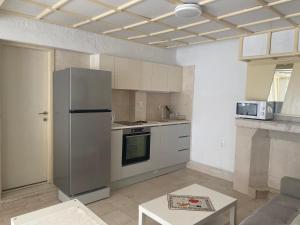 a kitchen with a stainless steel refrigerator and a table at Apartments Almaja Villa in Petrovac na Moru