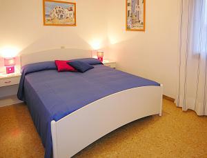 ビビオーネにあるAppartamenti Nettuno Pinedaのベッドルーム1室(大型ベッド1台、ナイトスタンド2台付)