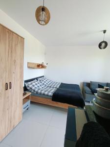 a bedroom with a bed and a couch at Dom Gościnny Helios in Mielno