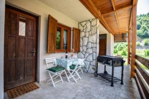a porch with a table and chairs and a grill at Apartment Lasica for 4 persons in Jasenak