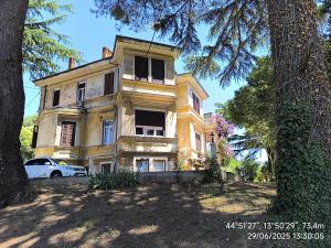 a yellow house with a car parked in front of it at GlamByAJ with free parking and Netflix in Pula