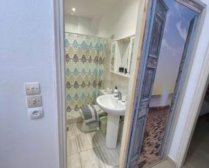 a small bathroom with a sink and a mirror at Kathrin apartments in Ipsos