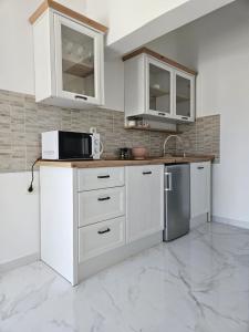 a kitchen with white cabinets and a microwave at Apartments Marija in Vir