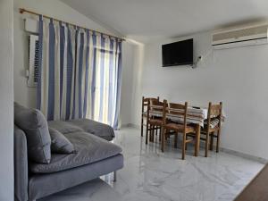 a living room with a table and chairs and a television at Apartments Marija in Vir