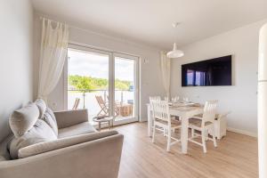 a living room with a couch and a table at Sunset Resort VI, Nadmorska 98A in Grzybowo