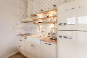 a kitchen with white cabinets and a sink at Sunset Resort VI, Nadmorska 98A in Grzybowo +57 photos
