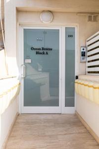a glass door with a sign that reads ocean breeze block at Modern&quiet ensuite room in St Paul's Bay +2 photos