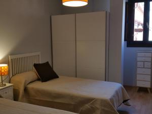 um quarto com uma cama, um armário e uma janela em Apartamento Capitania em Granada