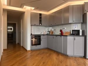 a kitchen with white cabinets and a wooden floor at Helen & Friends 3 bedrooms in Balchik