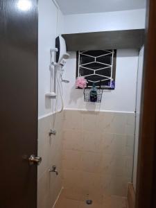 a bathroom with a shower and a window with flowers at Reddy Residence in Naulu