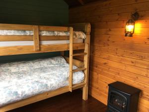 a bedroom with two bunk beds and a stove at Wild Meadow Camping in Llandysul