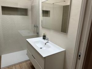 马尔萨拉Stagnone Sunset Holidays的一间白色浴室，配有洗手池和镜子。