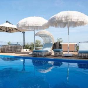 a swimming pool with two umbrellas and two chairs and a swimming pool at Lycian Village Luxury in Demre
