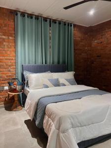 a bedroom with two beds and a green curtain at 1 Bedroom Sunset & Mountain View Chalet in Aburi in Aburi