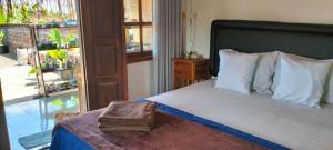 a bedroom with a bed with a large window at Rumah Sedana Ubud Centre in Ubud