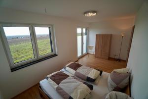 Un dormitorio con una cama y dos ventanas. en Ferienhaus Rebenhof, en Neustadt an der Weinstraße