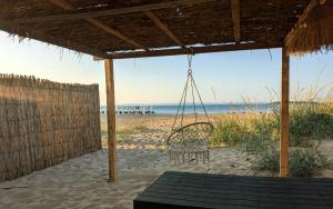 a swing on the beach with the ocean in the background at Каравана The Jungle in Chernomorets