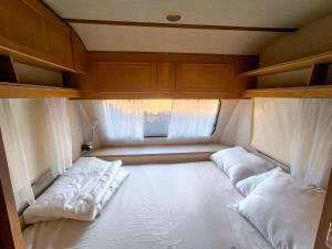 a small room with two beds and a window at Каравана The Jungle in Chernomorets