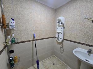 a shower with a mop in a bathroom with a sink at رياض صوفيا باي مرتيل in Martil +14 photos
