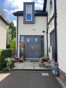 a house with a blue garage door and some plants at The Green Room guest suite in Belfast