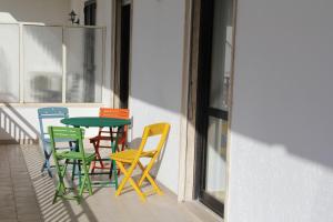 トリカーゼにあるCasa Pellaiのカラフルな椅子とテーブル付きのバルコニー