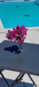 a vase of purple flowers on a table next to a pool at Villa Irene in Veli Lošinj