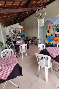 プラドにあるHostel chapéu e praiaのテーブルと椅子があり、壁に絵が飾られたレストラン +18枚の写真