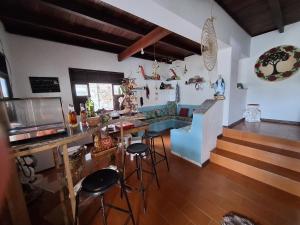 a kitchen with a table and stools in a room at Hostel chapéu e praia in Prado