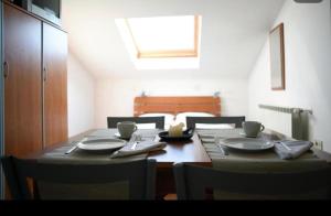 ein Esstisch mit Tellern und Stühlen und ein Fenster in der Unterkunft Apartment Sofia in Cres