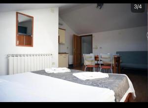 ein Schlafzimmer mit einem Bett, einem Tisch und Stühlen in der Unterkunft Apartment Sofia in Cres